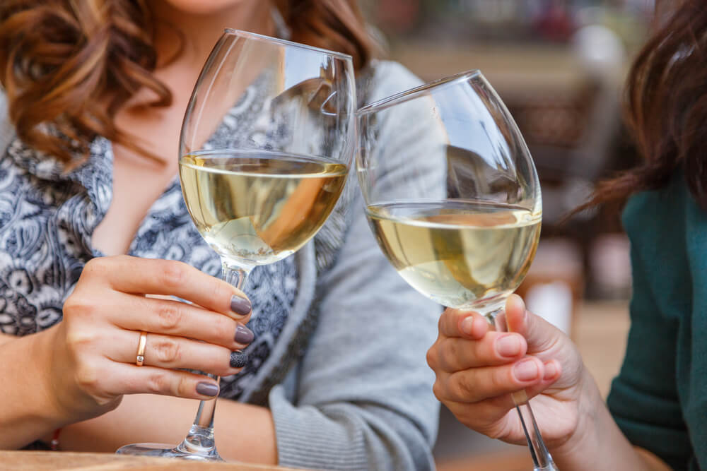Frauen trinken Wein, der die Funktion des Immunsystems negativ beeinflussen kann.
