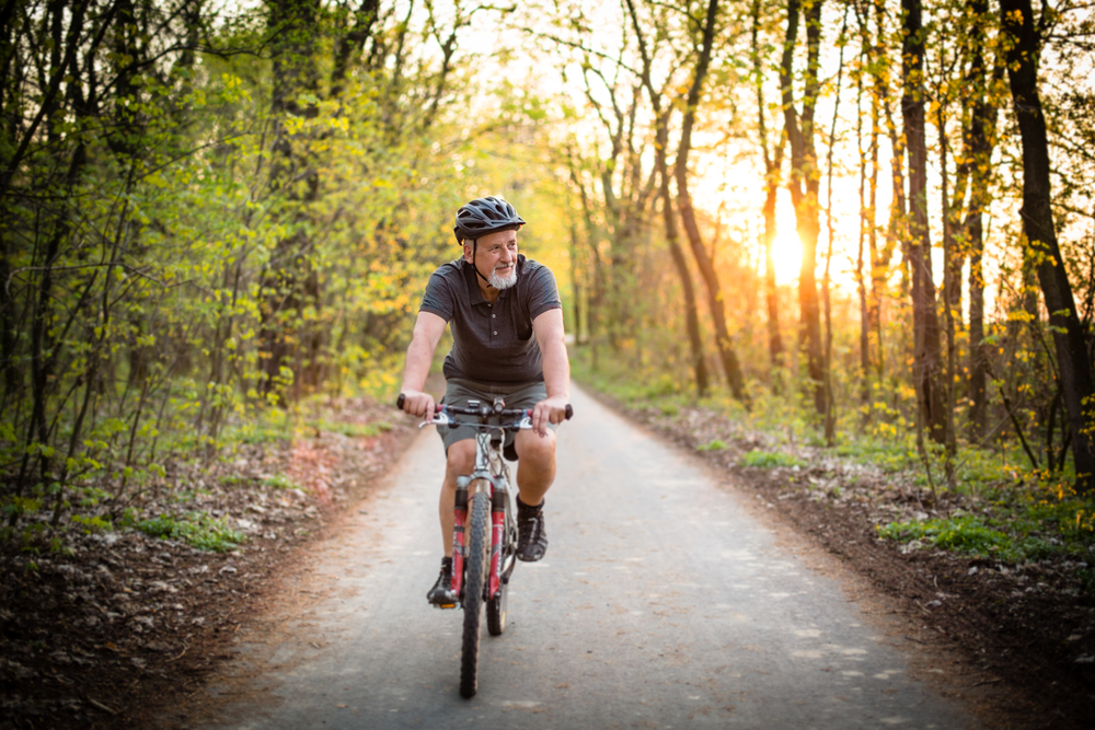 Ältere männliche Radfahrer fahren durch den Wald.