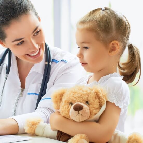 A little girl with a teddy is at the doctor’s.