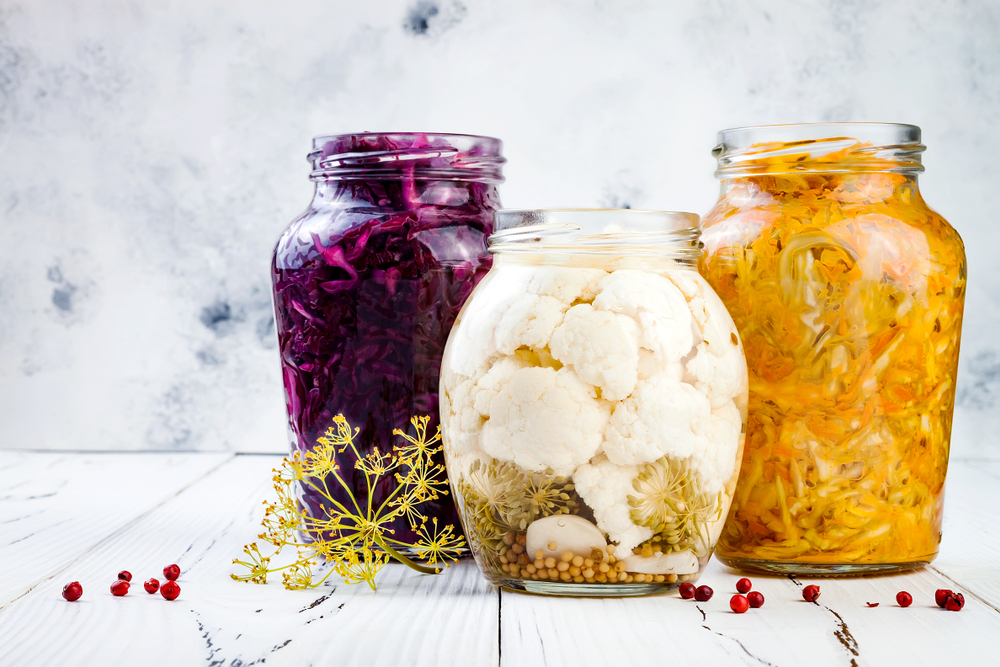 Fermented food in glass jars: red cabbage, white cabbage, carrots, cauliflower.