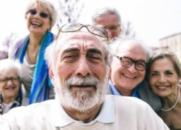 A group of elderly people are looking at the camera to take a picture.