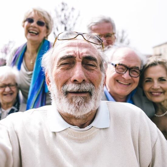 A group of elderly people are looking at the camera to take a picture.