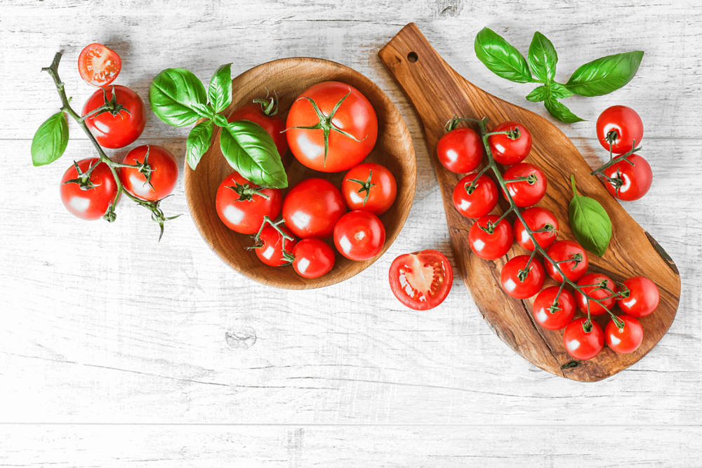 Regular and cherry tomatoes on a wooden board.
