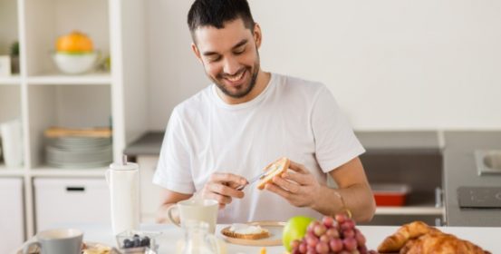The man laughs while preparing a healthy breakfast.