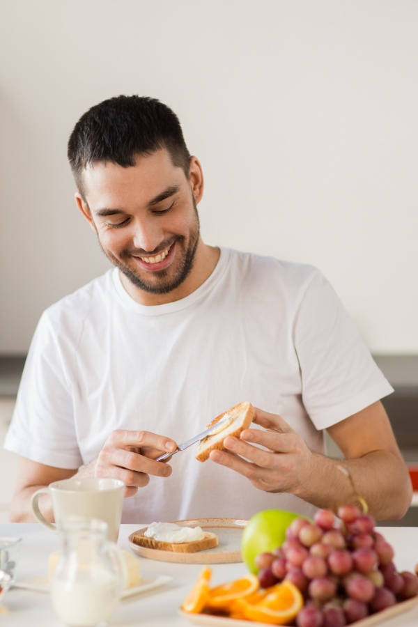 The man laughs while preparing a healthy breakfast.