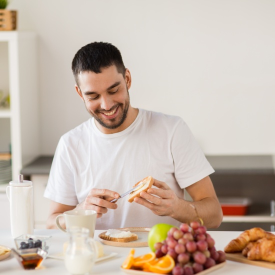 L'uomo ride mentre prepara una sana colazione.