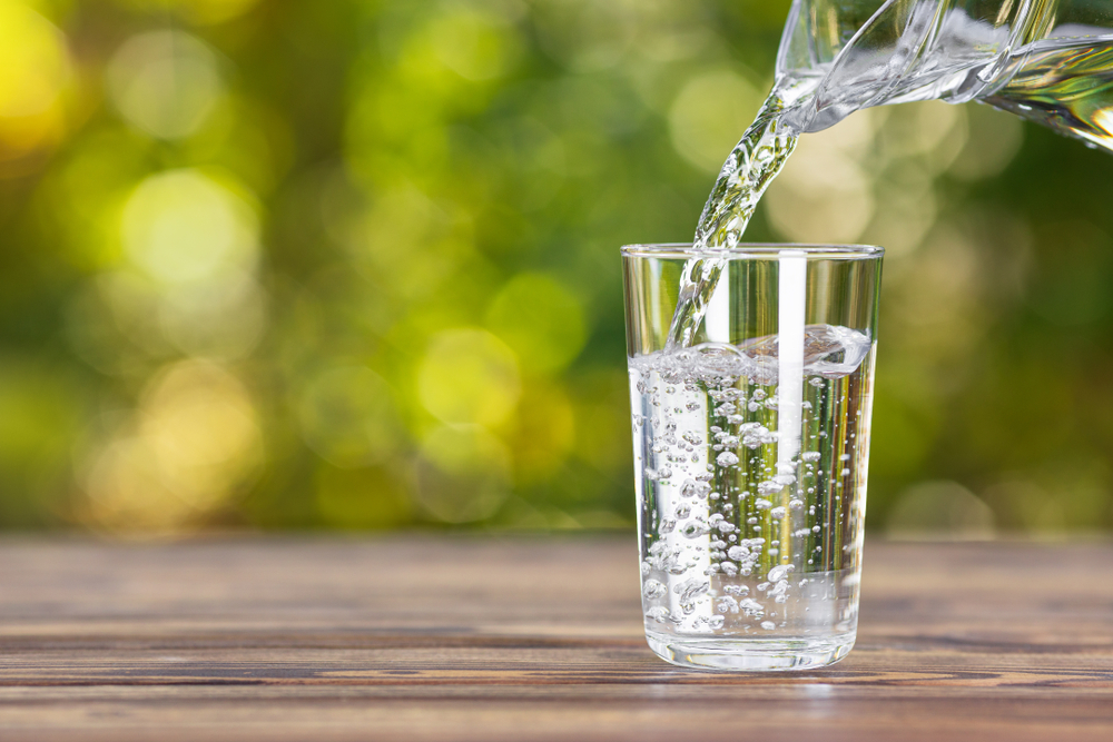 Versare l'acqua in un bicchiere.