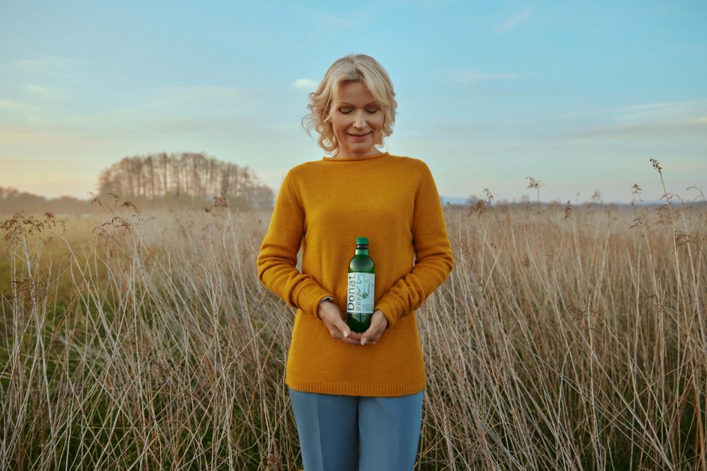 Eine Frau hält eine Flasche Donat Mg in den Händen.