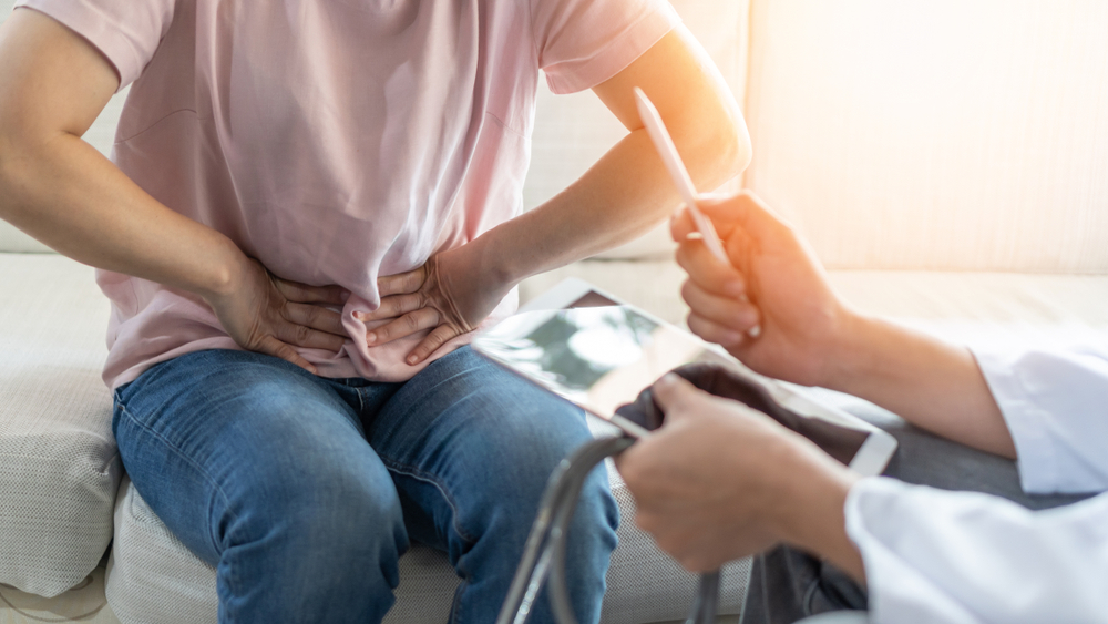 A man is at the doctor’s, and he is clutching his stomach.