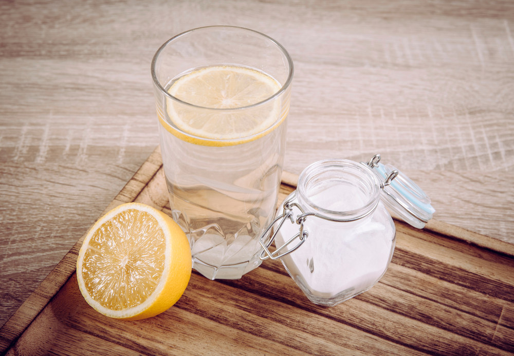 Backpulver in einem Glas zum Einweichen und Auflösen in einem Glas Donat-Mineralwasser.