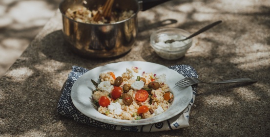 Salata od riže sa šparogama na keramičkom tanjiru.