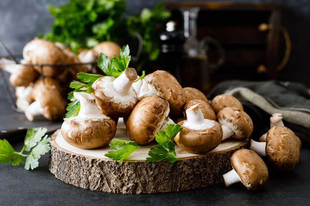 Mushrooms with parsley on a decorative wooden surface.
