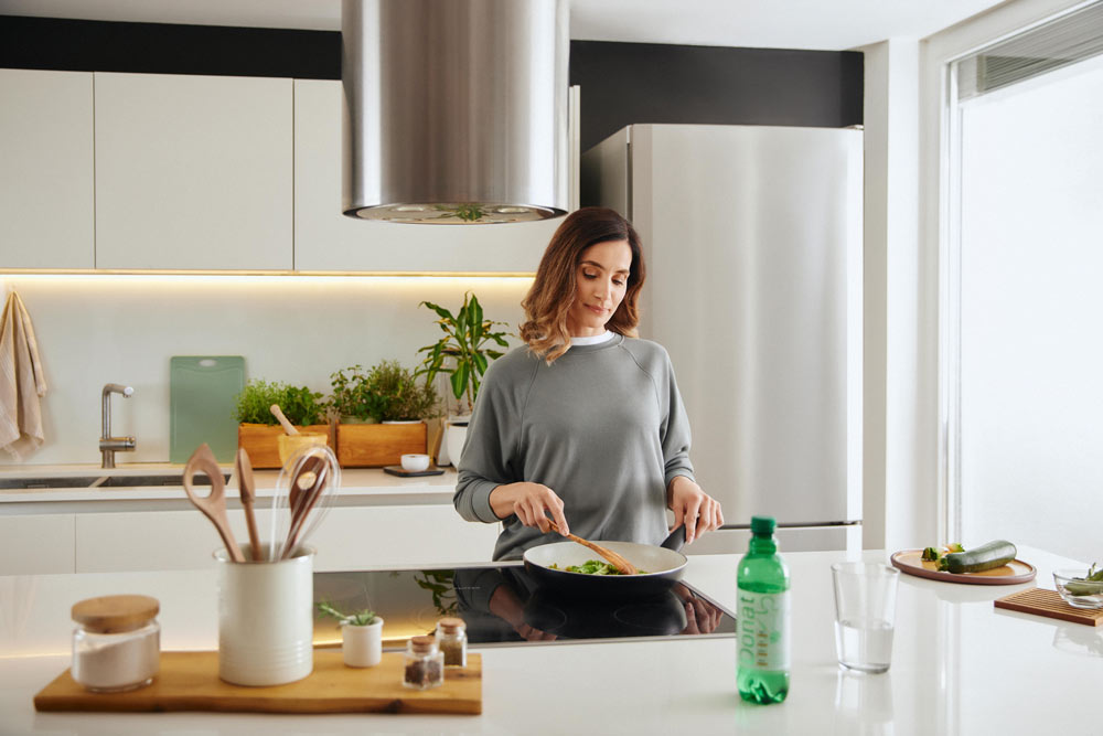 Una donna che prepara un pasto equilibrato per un sistema immunitario efficiente.