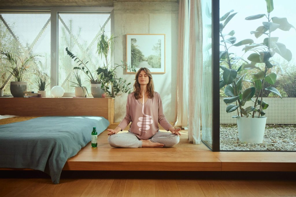 A woman meditating and practicing breathing exercises, which also help in fighting against heartburn.